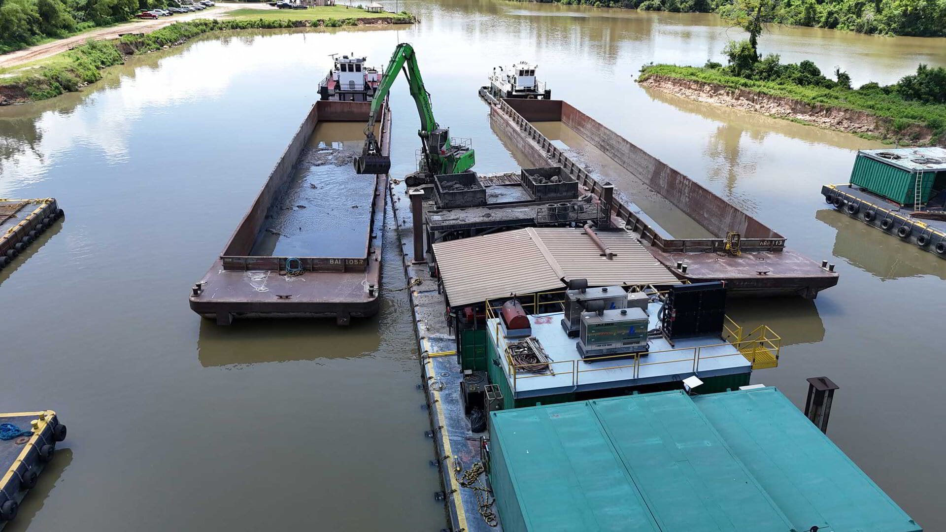 Clamshell bucket lifting material from the channel